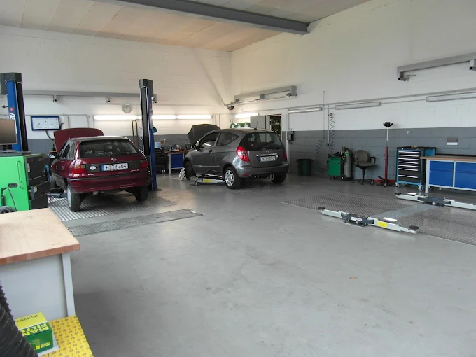 Innenansicht einer Werkstatthalle mit mehreren Fahrzeugen